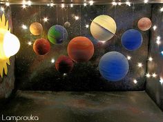 the solar system is lit up with lights and stars on it's ceiling, as well as hanging planets