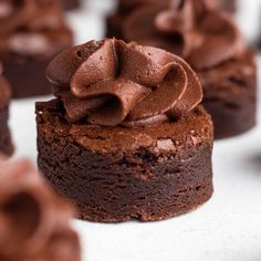 chocolate cupcakes with frosting sitting on top of each other