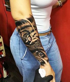 a woman's arm with a tiger tattoo on it and an eye in the middle