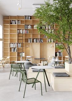 an empty library with many bookshelves and tables in the center, surrounded by chairs