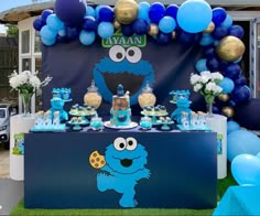 a sesame street birthday party with blue and gold balloons, cookie monster decorations, and desserts