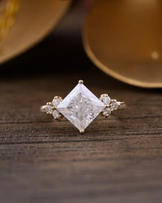 a white diamond ring sitting on top of a wooden table