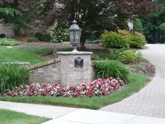 a lamp post in the middle of a flower bed