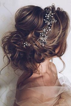 the back of a woman's head wearing a bridal hair comb with flowers on it