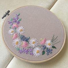 an embroidery project with daisies and other flowers