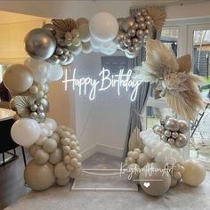 an arch made out of balloons with the words happy birthday written in white and gold