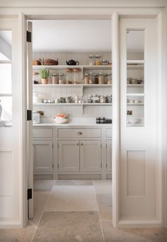 an open door leading to a kitchen with white cabinets