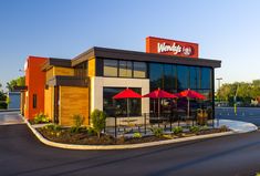 a mcdonald's restaurant with red umbrellas on the front and side of it