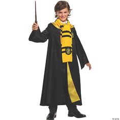 a young boy dressed in a harry potter costume holding a wand and smiling at the camera