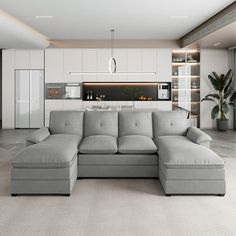 a living room with a large couch and a kitchen in the backgrounge