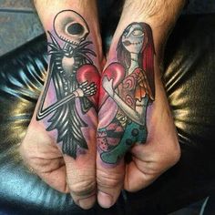 two people with tattoos on their hands holding each other's hands and one has a heart