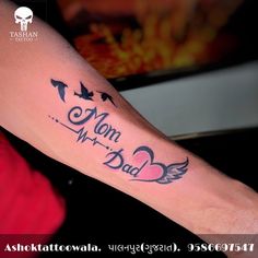 a woman with a tattoo on her arm that says mom, dad and two birds