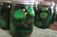 several jars filled with pickles and cucumbers