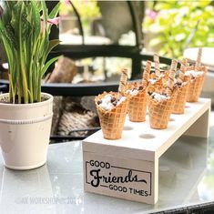 there are many cones that are on the table with flowers in them and one is filled with ice cream