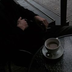 a man sitting at a table with a cup of coffee