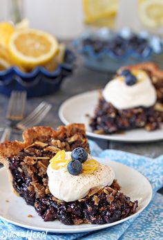 a slice of blueberry crumble cake on a white plate with lemons in the background