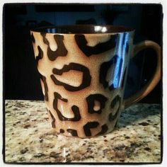 a leopard print coffee cup sitting on top of a counter