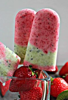 two popsicles with strawberries and kiwi on the side