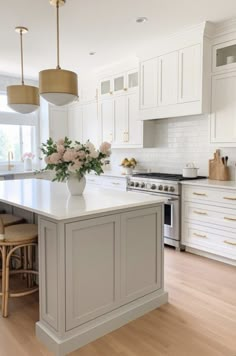 a large kitchen with white cabinets and an island