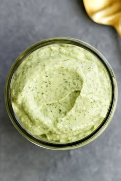 a small glass jar filled with green sauce