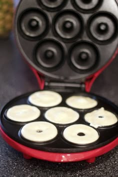 a waffle maker with eight donuts in it's pancake tray on a counter