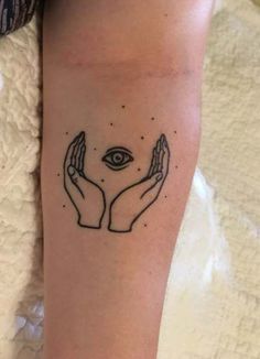 two hands holding an eye tattoo on the arm