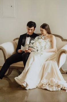 a bride and groom sitting on a couch