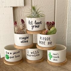 four ceramic planters with sayings on them