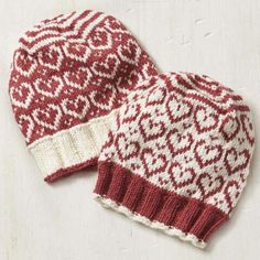 two red and white knitted hats sitting next to each other