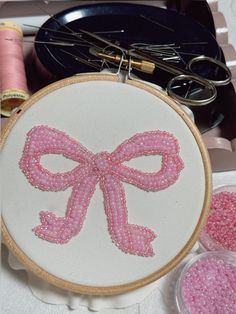 a close up of a embroidery on a table with scissors and other crafting supplies