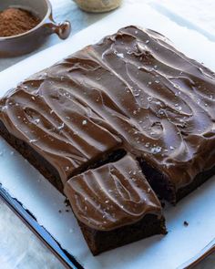 a chocolate cake with frosting on a white plate