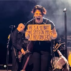 a man holding a sign while standing on stage