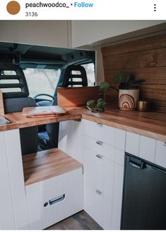 a kitchen with white cabinets and wood counter tops in the back of a truck or van