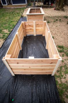 a wooden boat sitting on top of a black tarp