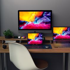 three computer monitors sitting on top of a wooden desk