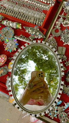 a person taking a selfie in front of a mirror with lots of jewelry on it