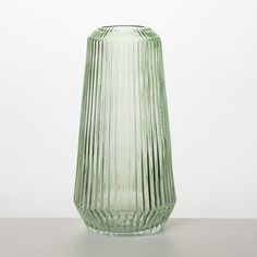 a green glass vase sitting on top of a table