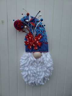 a white and blue santa claus hat hanging on a doorknob with red, white, and blue decorations