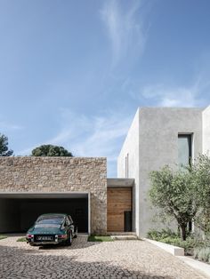 a car is parked in front of a house with two garages on each side