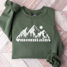 This Mountain Themed Sweatshirt is a perfect gift for all nature lovers who love the outdoors.  Also this Mountains Sweatshirt makes a perfect family vacation shirt.  Whether it's a gift for mom or dad, trail runners, cross country or hikers, they are sure to love it!   SUPER SOFT AND COZY CREWNECK SWEATSHIRTS AND HOODIES S H I R T / D E T A I L S Our sweatshirts are SUPER soft and SUPER comfy. For Women They Run Oversized! 50% Cotton/50% polyester and pre-shrunk.  We Use Soft and Cozy Gildan 18 Spring Outfits Mountains, Mountain Sweatshirt Design, Winter Adventure Long Sleeve Sweatshirt, Outdoor Fleece Hoodie Tops, Casual Fleece Sweatshirt For Hiking, Casual Fleece Sweater For Outdoor Activities, Long Sleeve Sweatshirt For Fall Outdoor Activities, Relaxed Fit Fleece Top For Outdoor, Outdoor Hoodie With Letter Print In Relaxed Fit