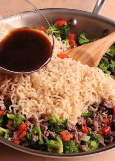 a skillet filled with noodles, broccoli and sauce