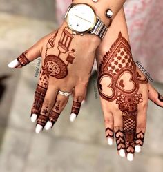 two hands with henna designs on them and a watch in the middle one hand