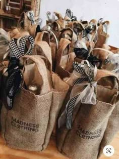 burlap bags with black and white bows are stacked on top of each other