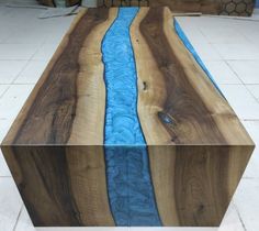 a wooden table with blue water flowing down the center and sides on top of it