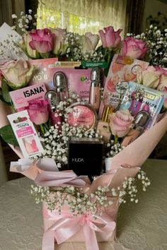 a pink basket filled with lots of pretty flowers and personal care products on top of a table