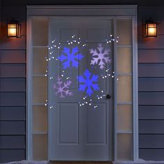 snowflakes on the front door of a house lit up with blue leds