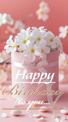 a pink birthday card with white flowers in a gift box on a pink background that says happy birthday