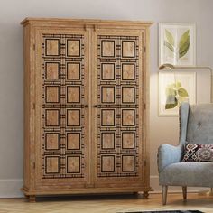 a room with a chair, armoire and rug on the floor in front of it