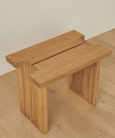 a wooden bench sitting on top of a hard wood floor