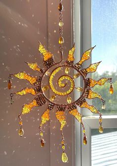 a sun - shaped chandelier hanging from a window